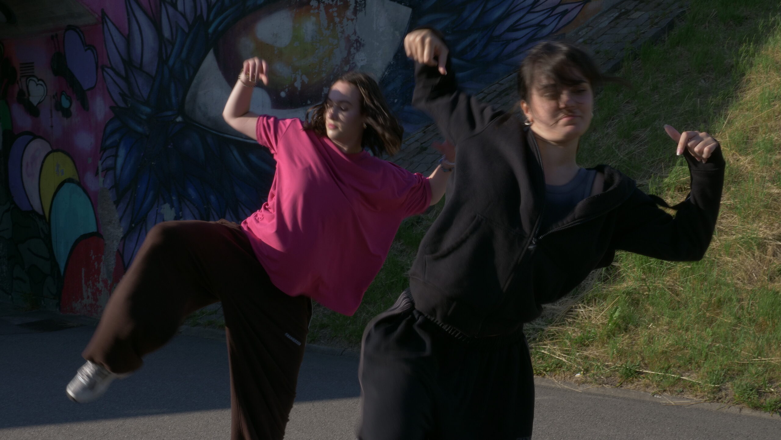 Två tjejer dansar och lyfter sina händer och ben